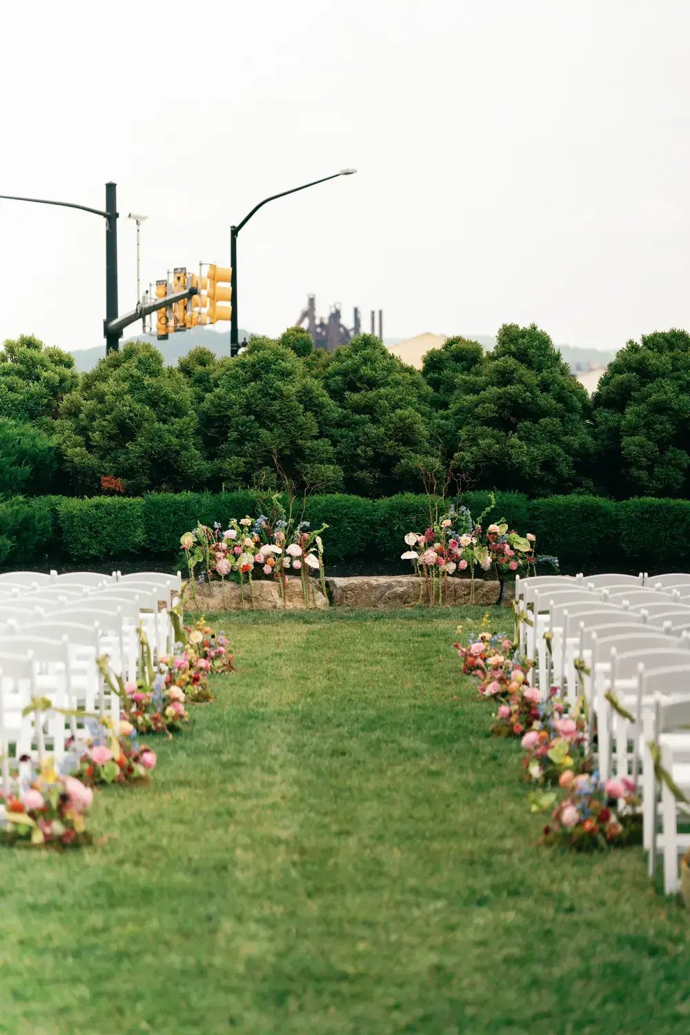white folding chairs in a manicured garden setting.