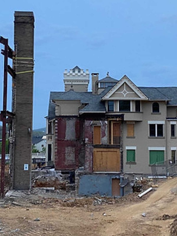 The Wilbur Mansion during its renovation phase, showing construction work, scaffolding, and partially restored exterior walls.